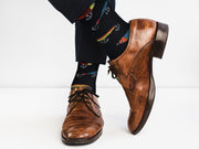 Black fishing lure pattern socks on feet with sneakers on skateboard outdoors